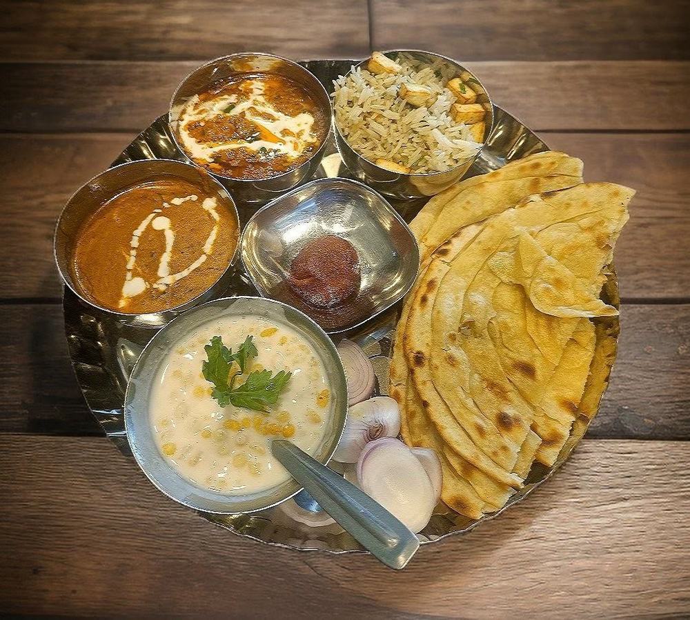 Veg thali with paratha, curries, raita and rice